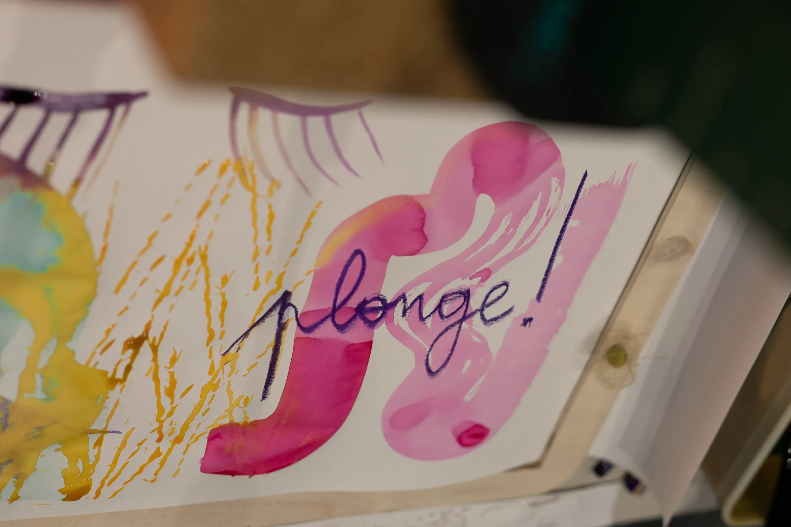Carnet ouvert sur une page aquarellée où est écrit « plonge ! »