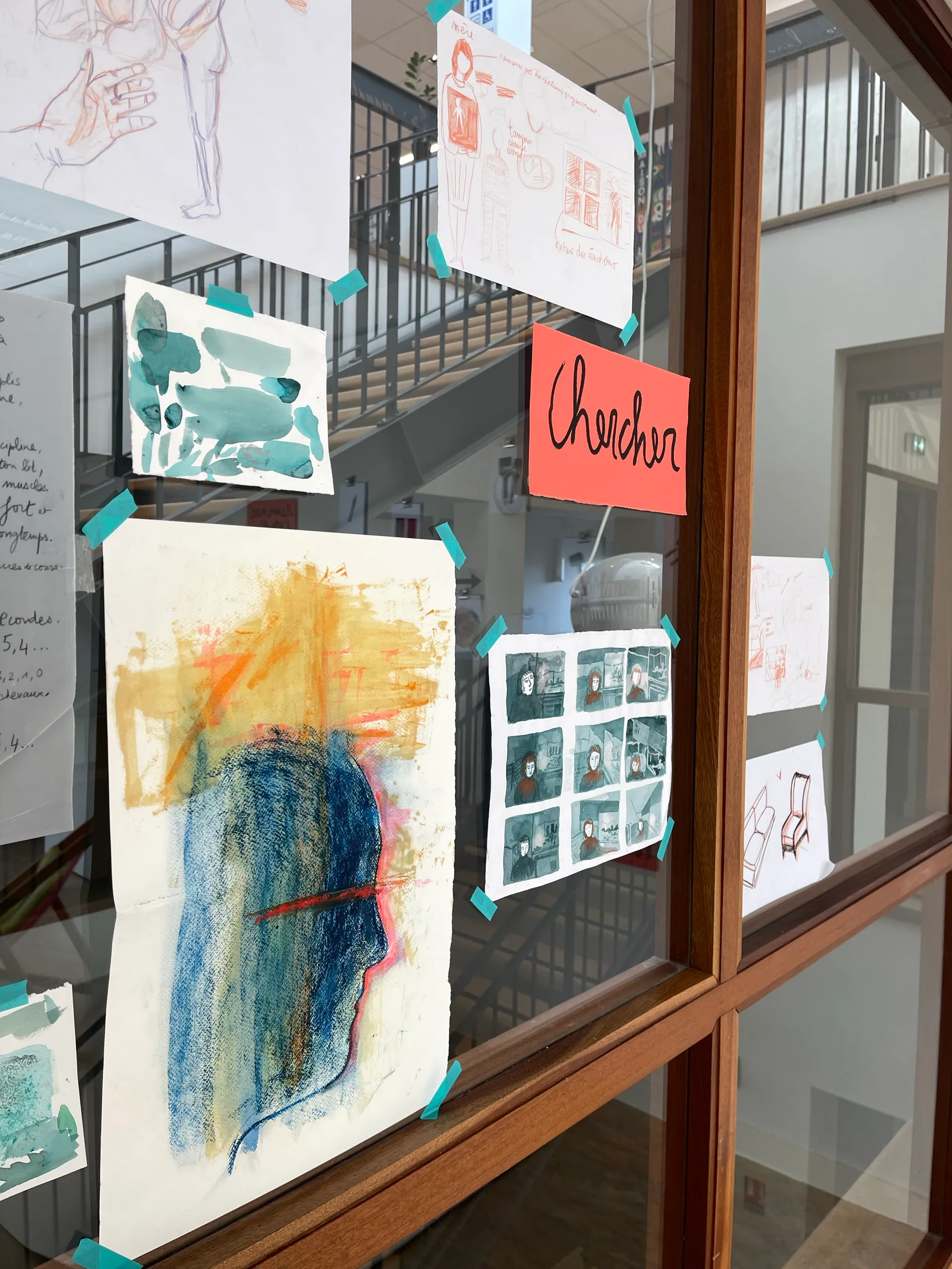 Planches et recherches exposées sur une verrière pendant l’exposition À la racine